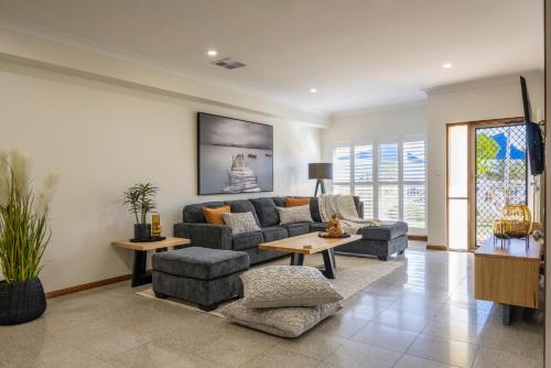 a living room with a couch and a table at Christies Breeze a luxurious getaway by the sea in Christies Beach