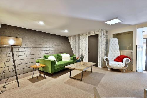 sala de estar con sofá verde y silla en The Birch Ridge- Colonial Maple Room #1 - Queen Suite in Renovated Killington Lodge home en Killington