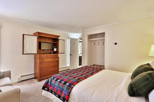 a bedroom with a bed and a television and a dresser at The Birch Ridge- Lace Room #3 - Queen Suite in Renovated Killington Lodge, Hot tubs, home in Killington