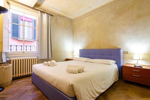 - une chambre avec un grand lit et des serviettes dans l'établissement Casa Diamanti, à Bologne