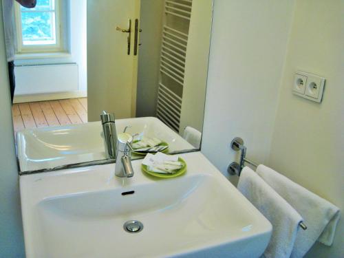 a white bathroom with a sink and a mirror at Garden Residence Prague Castle in Prague