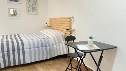 a bedroom with a table and a bed and a table and chair at Loft en Veracruz in Veracruz