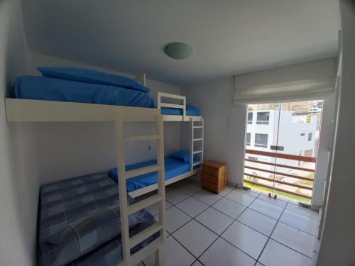普庫薩納區的住宿－DÚPLEX CON VISTA A TODA LA BAHÍA DE NAPLO，一间卧室设有两张双层床和一扇窗户。