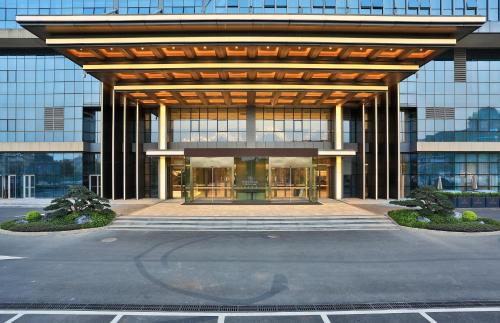 a large glass building with a large entrance at Yiwu Yandoo Yayue Hotel in Yiwu