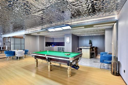 a room with a pool table and blue chairs at Yiwu Yandoo Yayue Hotel in Yiwu