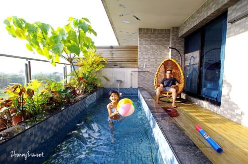 dos personas sentadas en una piscina en una casa en Grand Allevia Villa en Wujie