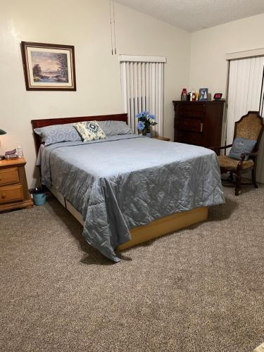 a bedroom with a bed and a chair and a dresser at Cozy Guest House Florida, 5801 in Sunrise