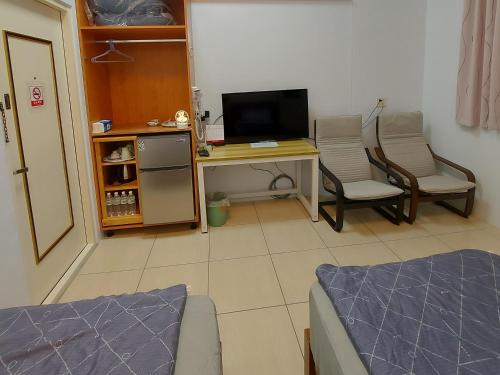 a room with a desk with a computer and two chairs at 南田旅宿 in Fengyuan