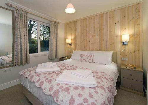 a bedroom with a bed with two towels on it at Jamies Cragg Holiday Park in Welburn