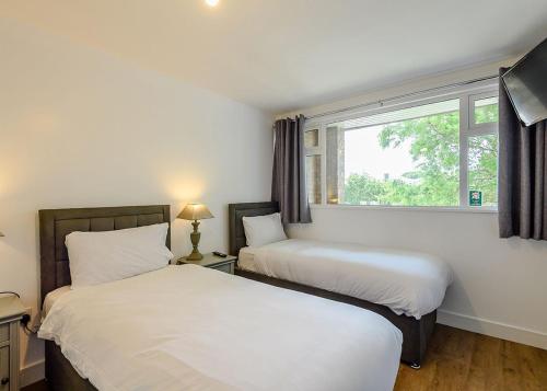 Duas camas num quarto com uma janela em North Shore Holiday Park em Winthorpe