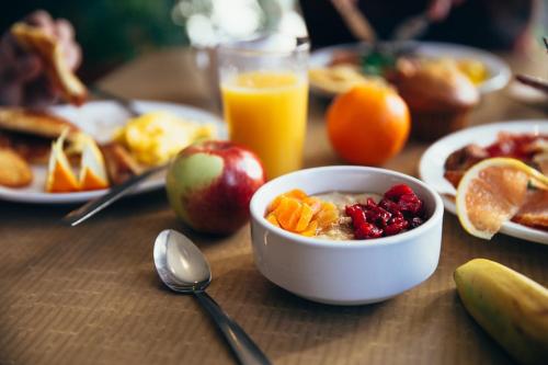 a table with a bowl of cereal and fruit and a glass of orange juice at Miri Marriott Resort & Spa in Miri