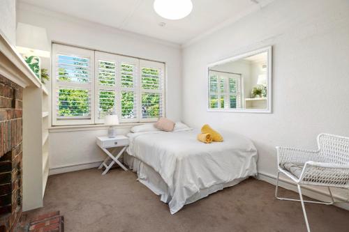 a bedroom with a bed and two windows at St Kilda Style - Stunning 3 Bedroom House in Melbourne