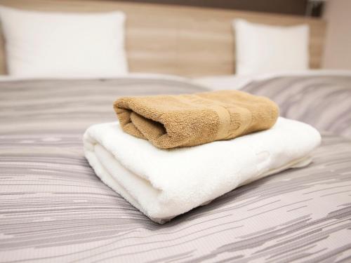 Postel nebo postele na pokoji v ubytování Hotel Route Inn Kyoto Maizuru -Nishi Maizuru Ekimae-
