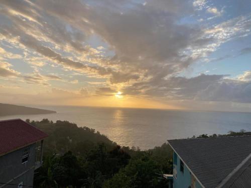 Blick auf das Meer bei Sonnenuntergang von einem Haus aus in der Unterkunft Best View Apartments in Anse La Raye