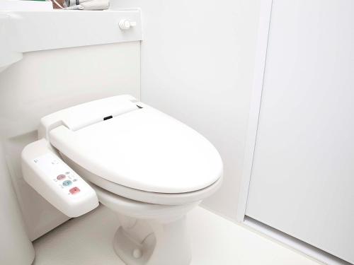 een wit toilet in een badkamer met een spiegel bij Hotel Route Inn Kyoto Maizuru -Nishi Maizuru Ekimae- in Maizuru