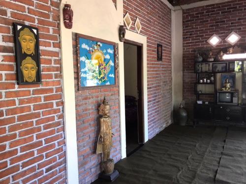 a brick wall with paintings on it and a doorway at Les Cantik Homestay in Tejakula