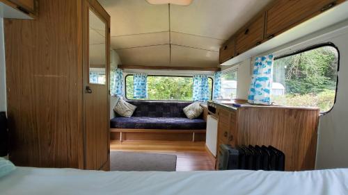 a bedroom with a couch in the back of a rv at Dickson Holiday Park in Thames