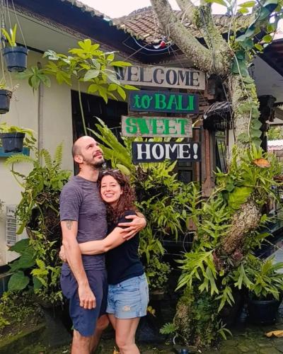 a man and a woman standing in front of a building at Coliving Bali SWEET HOME Kost Lengkap di Tabanan Kota in Tabanan