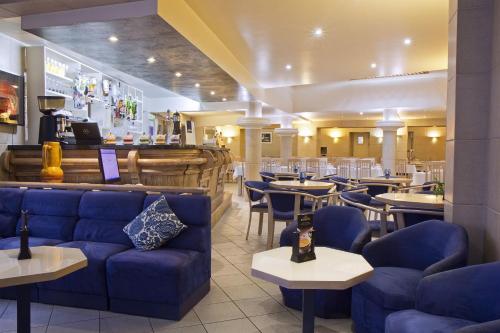 Hôtel Atlantic في لورد: مطعم به أرائك وطاولات زرقاء وبار