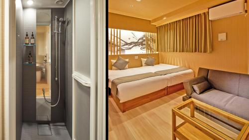 a bedroom with a bed and a couch and a shower at Stay SAKURA Tokyo Shinjuku Hyakukura in Tokyo