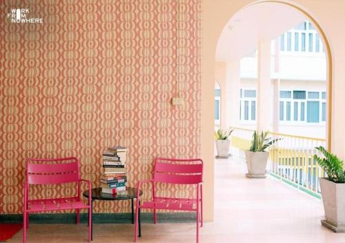 2 chaises et une table dans une chambre avec un mur dans l'établissement Miami Hotel Bangkok - SHA Plus, à Bangkok