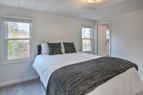 - une chambre avec un grand lit et 2 fenêtres dans l'établissement Cozy Asheville Cottage with Grill and Fire Pit!, à Asheville