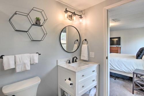 La salle de bains est pourvue d'un lavabo, d'un miroir et d'un lit. dans l'établissement Cozy Asheville Cottage with Grill and Fire Pit!, à Asheville