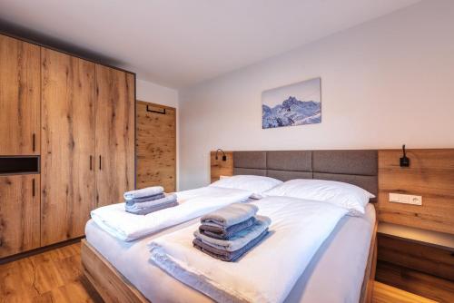 ein Schlafzimmer mit einem Bett mit Handtüchern darauf in der Unterkunft Am Römerweg - Appartements in Sankt Anton am Arlberg