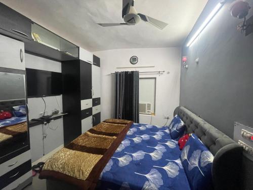 Schlafzimmer mit einem Bett und einem Deckenventilator in der Unterkunft Jindal’s in Dehradun
