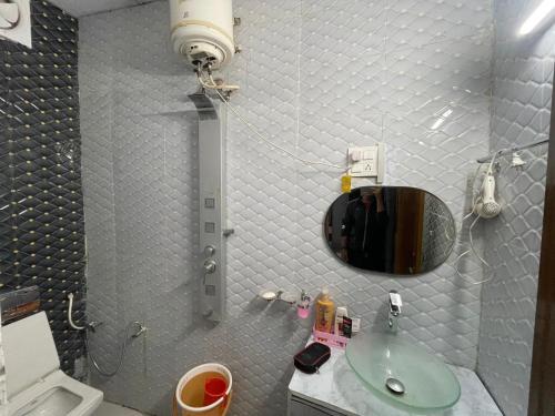 ein kleines Bad mit einem Waschbecken und einem Spiegel in der Unterkunft Jindal’s in Dehradun