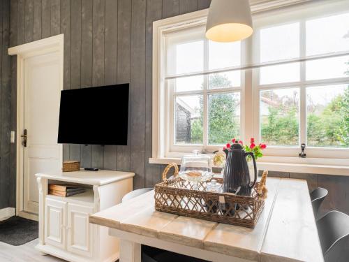 sala de estar con mesa y TV en Quaint Summer Holiday Home in Egmond Binnen, en Egmond-Binnen