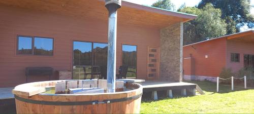 a building with a fountain in front of a house at Paraíso Liumalla Lodge in Villarrica