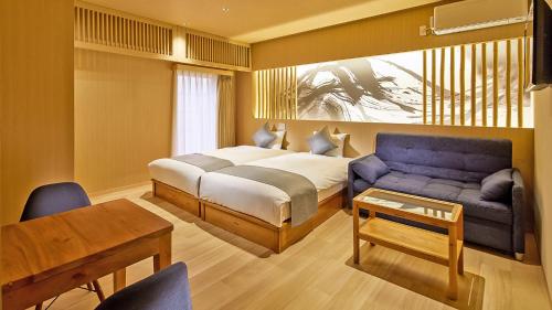 a bedroom with a bed and a couch and a table at Stay SAKURA Tokyo Shinjuku Hyakukura in Tokyo