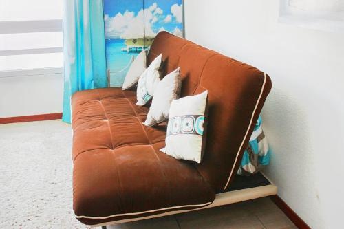 a brown leather couch with white pillows on it at Studio 22 square meters In The Center Of Lyon in Lyon