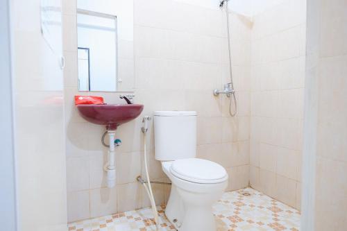 a bathroom with a toilet and a sink at RedDoorz near Tugu Pers Jambi in Jambi