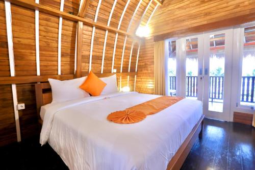 1 dormitorio con 1 cama con sombrilla naranja en 37 Sunset Village Bali, en Canggu
