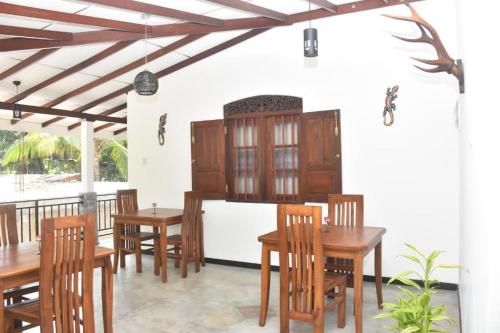 a dining room with wooden tables and chairs at Neo Grand Villa in Galle