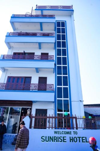 a white building with a welcome to sunrise hotel at Sunrise Hotel in Bharatpur