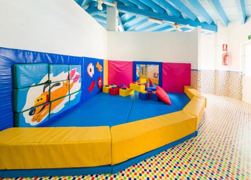 uma sala de jogos com uma grande cama amarela num quarto em Coral Star Apartments em San Antonio Bay