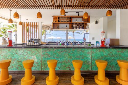 a bar with yellow stools in front of a counter at The Pearl Hoi An in Hoi An