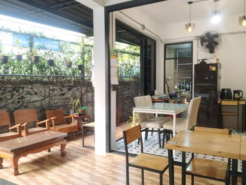 a dining room with tables and chairs and a wall with plants at Ban Pongphan in Chiang Mai