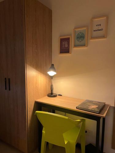 a desk with a lamp and two green chairs at HOTEL 9.5 SAN FERNANDO in Cali
