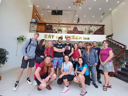 um grupo de pessoas posando para uma foto em um edifício em Cat Ba Green Hotel em Ilha de Cát Bà
