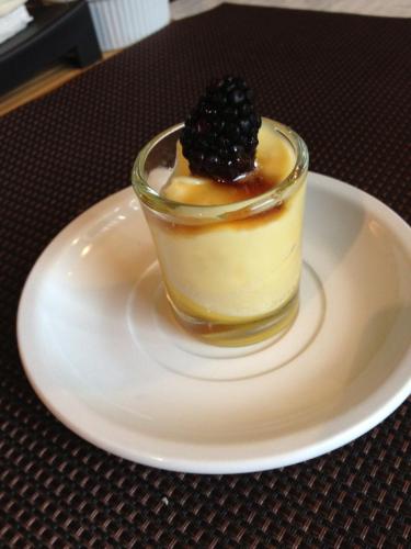a dessert with a blackberry on a white plate at Repos & Manna Downtown Montréal in Montréal