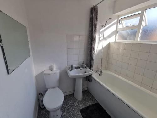a white bathroom with a toilet and a sink at 6 beds sleeps 8 detached house with private drive in Upper Penn