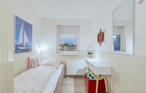 a white room with a bed and a desk at Appartement Seestern D in Schönhagen