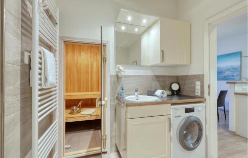 a bathroom with a sink and a washing machine at Appartement Seestern D in Schönhagen