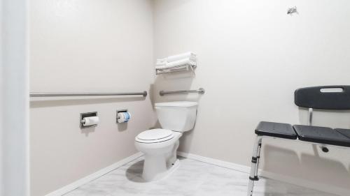 a bathroom with a toilet and a chair in it at Ocean Star Inn in Sequim