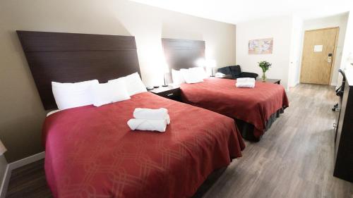 two beds in a hotel room with white towels on them at Ocean Star Inn in Sequim