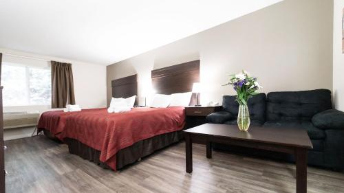 a hotel room with a bed and a couch at Ocean Star Inn in Sequim